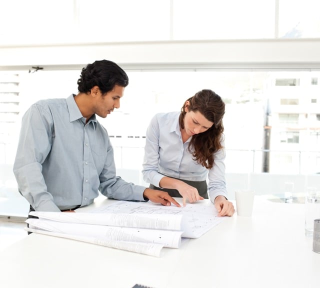 two people looking at building plans